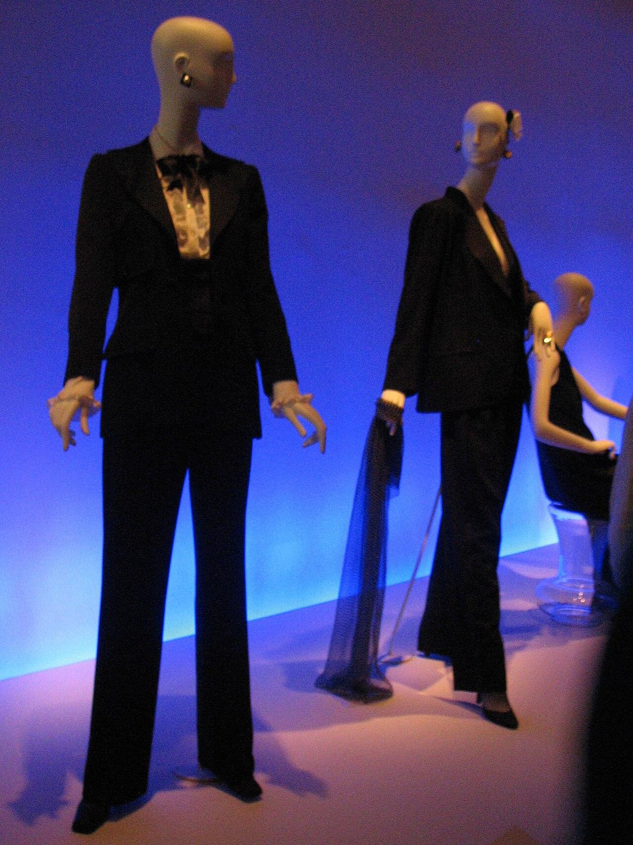 Zwei schwarze Smoking-Anzüge mit Hose auf Schaufensterpuppen im blauen Licht einer Museumsvitrine